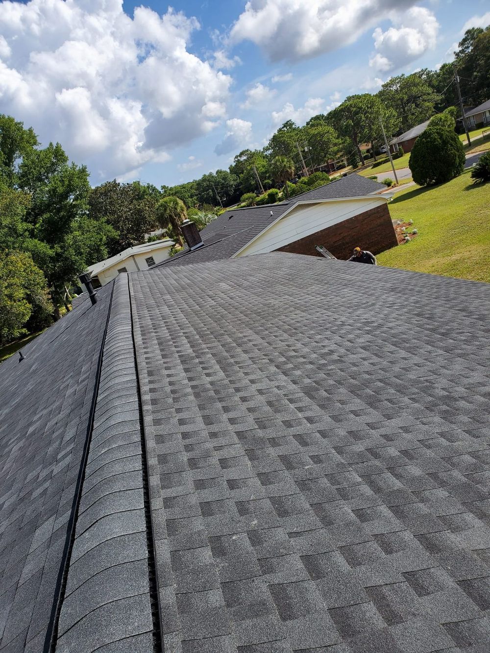 Roofer completing repairs on architectural shingle roof